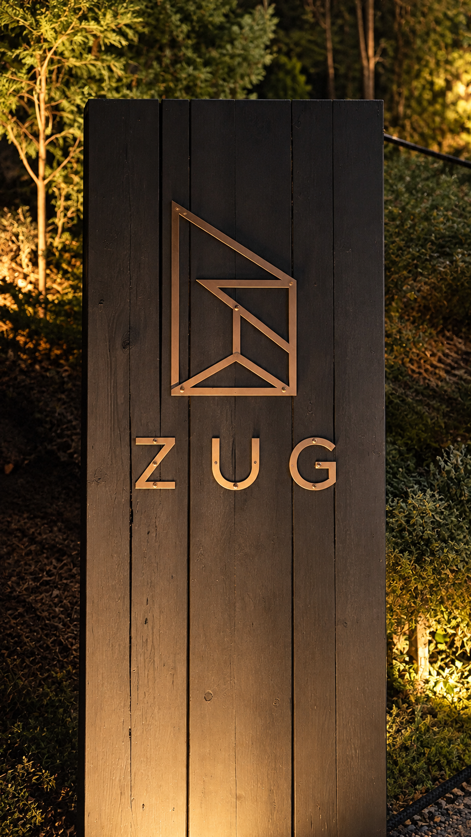 A ZUG kültéri logótáblája esti fényekben.
